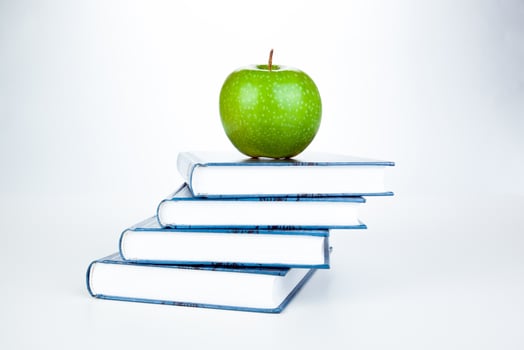 stack of books with green apple photo