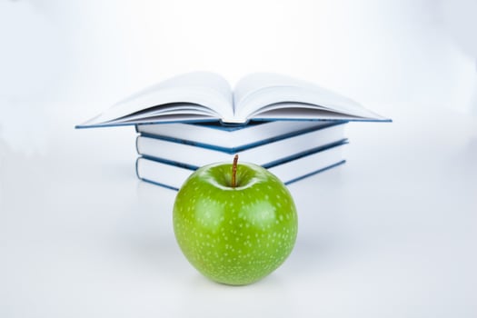 stack of books with green apple photo