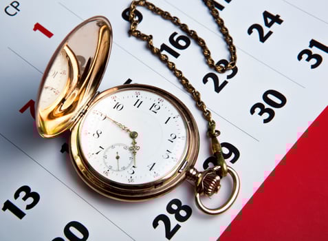 Gold pocket watch and a wall calendar photo