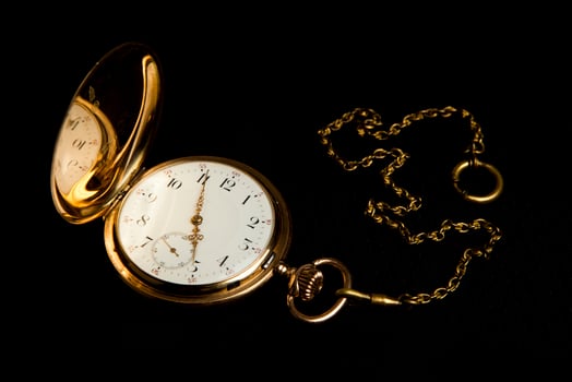 Gold pocket watch on black cloth photo