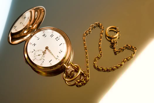Gold pocket watch on gold glass background photo