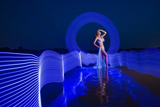 Young slim girl posing in water with abstract blue light effect photo