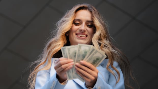Bottom view close up happy successful caucasian young business woman checking amount of cash money dollars counting finance salary rejoice with payment. Smiling girl holding hundred bill banknotes photo