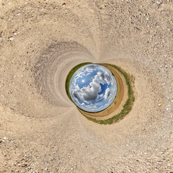 blue hole sphere or globe little planet inside sand or dry ground frame background with tractor tracks photo