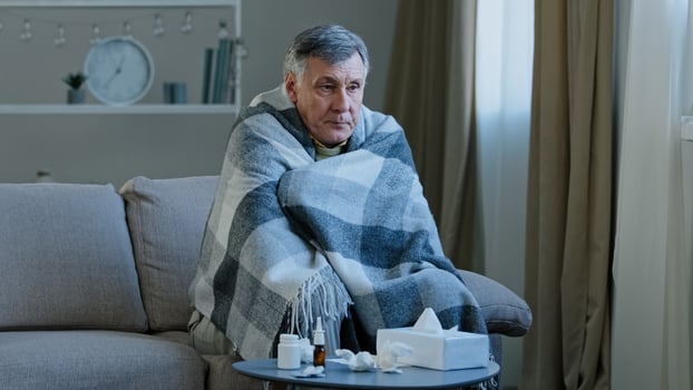 Ill caucasian elderly grandpa sit in covered with blanket on couch at home with cold remedy unhealthy senior adult man having symptoms flu signs coronavirus feeling chills respiratory diseases covid19 photo