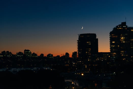View of buildings illuminated in the city on coastline at Vancouver, Canada, photo