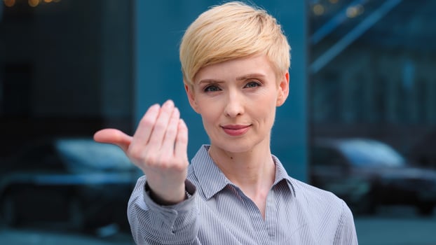 Portrait of beautiful caucasian middle aged adult 40s business woman friendly lady smiling showing gesture of invitation advice to approach herself with hand asks to come outdoors, body languages photo