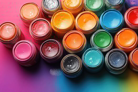 Colorful paint cans arranged on artist's workbench forming a creative background for design photo
