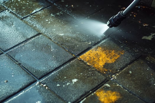 Cleaning service worker using high pressure water jet cleaning city street photo