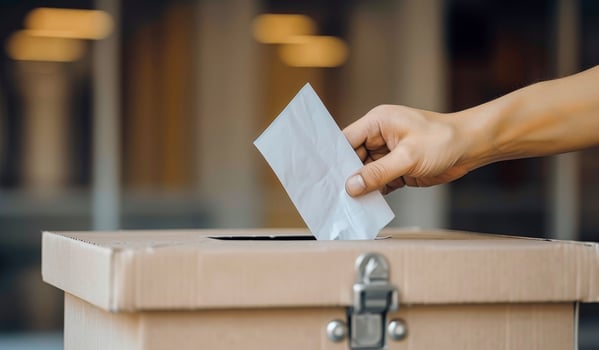 A person is throwing a piece of paper into a box photo