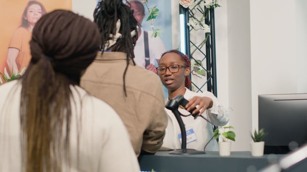 Customer finishing shopping in elegant clothing shop, paying for clothes at checkout counter, helped by friendly worker. Retail clerk assisting buyer with his purchases in fashion boutique photo