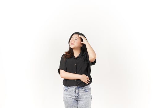 Young Asian woman doing thinking gesture wearing Black t-shirt and jeans isolated on white background photo