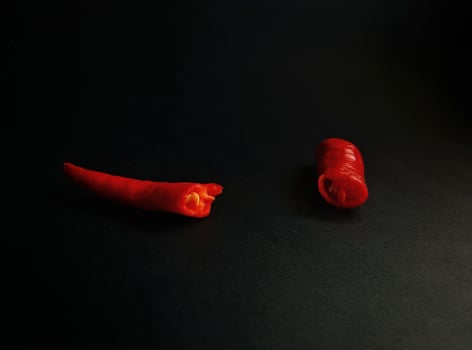 Two red peppers on a black surface photo