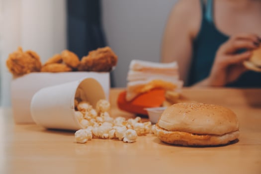 fast food, people and unhealthy eating concept - close up of woman hands holding hamburger or cheeseburger photo