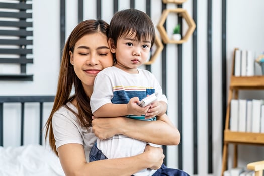 Portrait of a beautiful asian mother with her cute little son with pleasure spending time together, Young mom hugging on a back child, happy family life, enjoying family time together photo