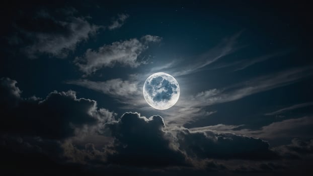 A luminous full moon obscured partially by fast-moving clouds, creating a dynamic interplay of light and shadow. photo