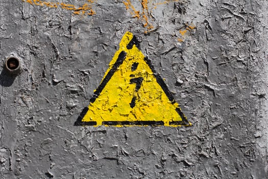 The sign of electrical hazard on a gray coarse metaic painted surface photo