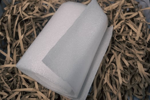 A roll of styrofoam on a piece of brown paper. photo