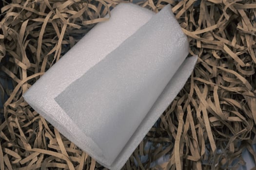 A roll of styrofoam on a piece of brown paper. photo
