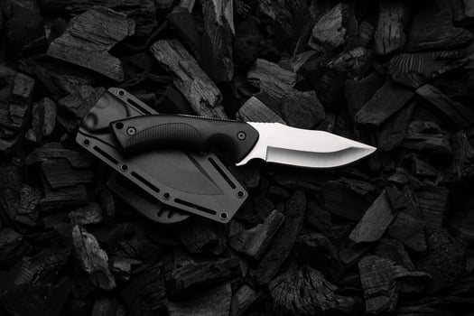 Modern knife with silver blade. Hunting, military knife on smoldering charcoal. Black back. photo