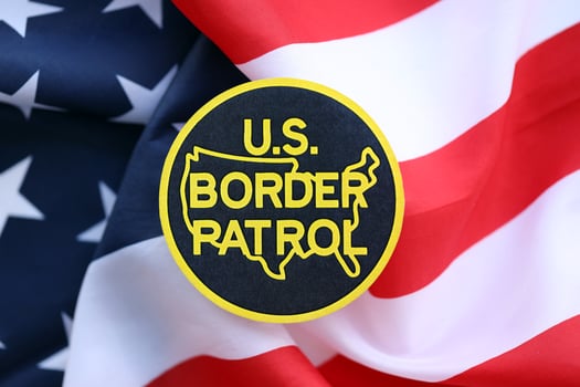 KYIV, UKRAINE - JUNE 26, 2024 U.S. Border Patrol coat of arms sticker on folded US flag photo