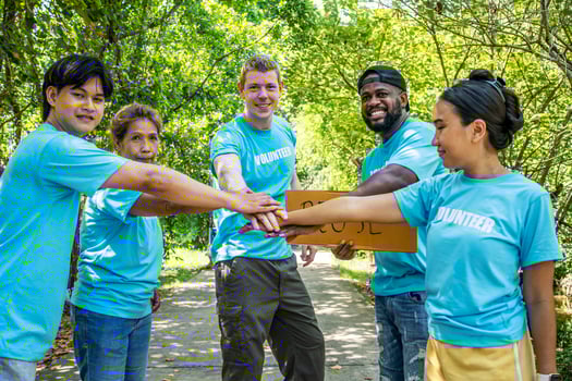 Group of volunteers stand to put your hands up and raise your hands together for help to save nature collecting garbage, Natural environment, pollution concept, Cleaning of nature from waste photo