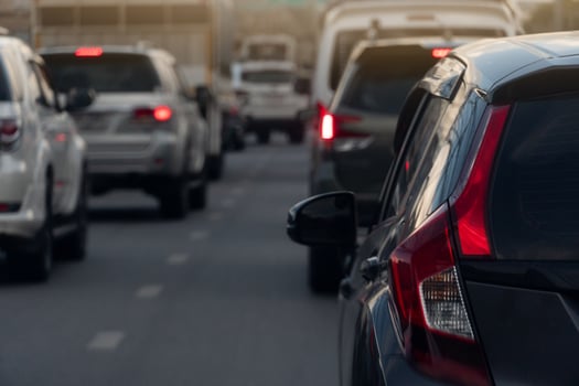 Rear side of black car on the aspahlt road. Transtport of car turn on brake light in the business time environment of moring time. Traffic congestion and queues of cars. photo