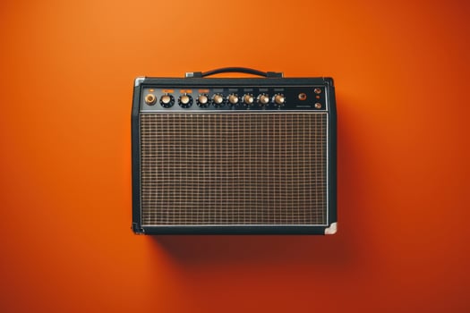 Vintage amplifier against a vibrant orange wall during a creative music session photo