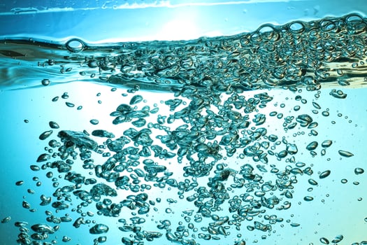 Fresh Water With Underwater Bubbles Texture on a Blue Background Close-up Abstract Liquid Bubbles Aqua Design Wallpaper photo