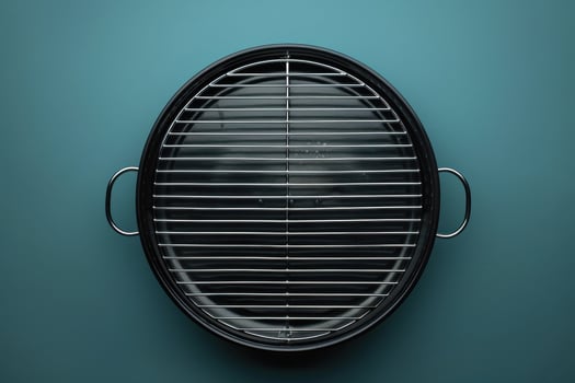 A stylish charcoal grill awaiting summer barbecues, set against a vibrant teal background, ready for outdoor gatherings photo