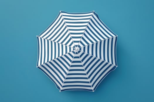 A vibrant blue and white striped umbrella rests against a solid blue background, evoking summertime relaxation and beach days photo
