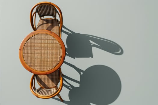 A rustic wooden table with woven chairs casting gentle shadows in warm afternoon light photo