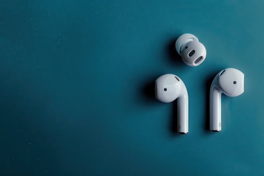 Modern wireless earbuds on a teal background, showcasing sleek design and innovative technology for an immersive audio experience photo