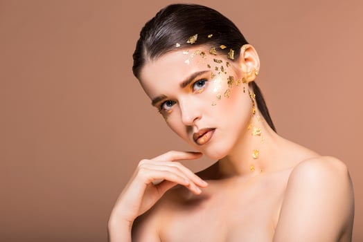 Portrait of a beautiful young woman with bright golden make up photo