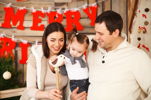 Family with one year daughter near the Christmas background photo