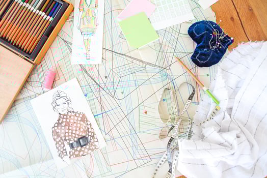 Table of the tailor with fabric, sketches and sewing equipment photo