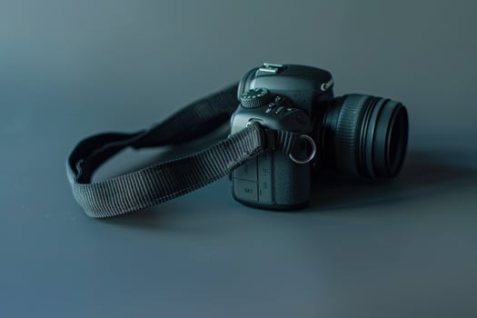 A sleek black camera resting elegantly on a subtle gray background, capturing the essence of creativity and innovation in photography photo