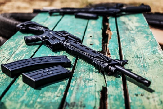 Black automatic shotgun on a green wooden table photo