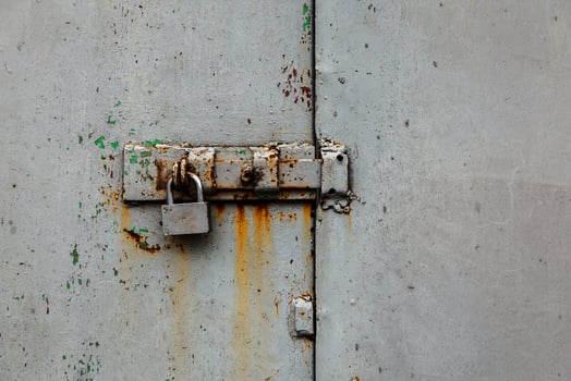 Padlock with bolt on an old metal rusty door photo