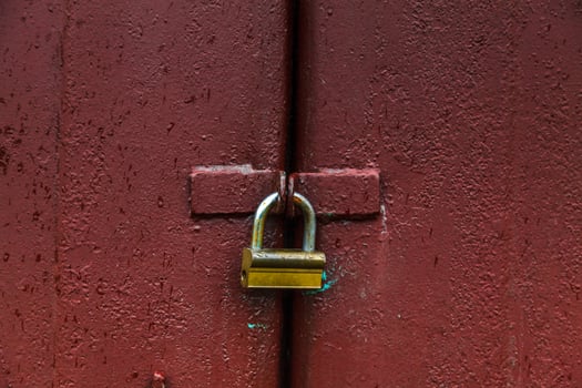 Padlock on red metal door photo