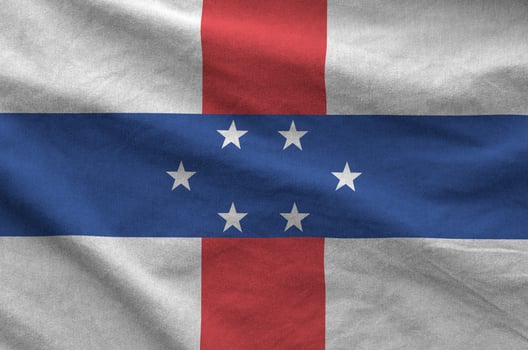 Netherlands Antilles flag depicted on folded wavy fabric of old cloth photo