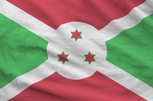 Burundi flag depicted on folded wavy fabric of old cloth photo