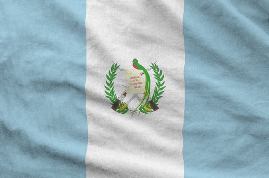 Guatemala flag depicted on folded wavy fabric of old cloth photo