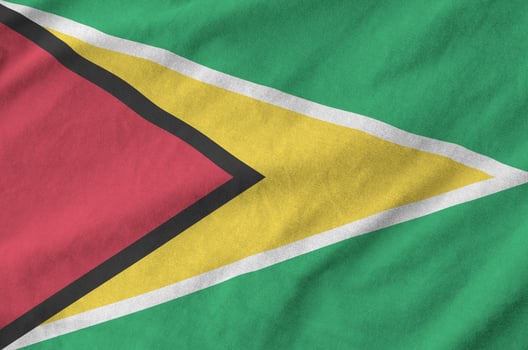 Guyana flag depicted on folded wavy fabric of old cloth photo