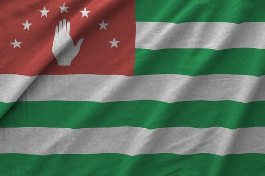 Abkhazia flag depicted on folded wavy fabric of old cloth photo