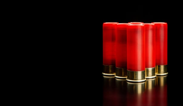 Shotgun shells on a black reflective surface. Ammunition for 12 gauge smoothbore weapons. Hunting ammunition. Dark back. photo