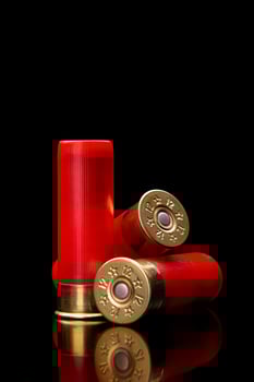 Shotgun shells on a black reflective surface. Ammunition for 12 gauge smoothbore weapons. Hunting ammunition. Dark back. photo