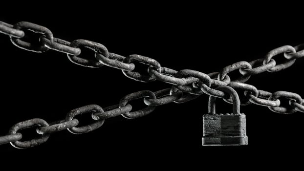 Worn rusted chain and pad lock on black background. Conceptual strength, protection, or security system. photo
