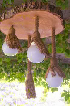 A lamp of electric light in a rope and cut down a tree in a summer arbor. Wooden lamp. Decor element. photo