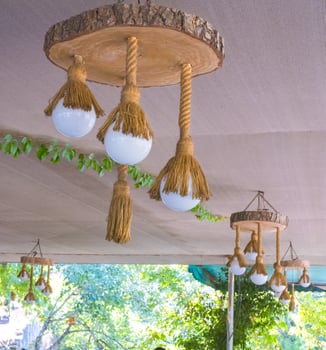 A lamp of electric light in a rope and cut down a tree in a summer arbor. Wooden lamp. Decor element. photo